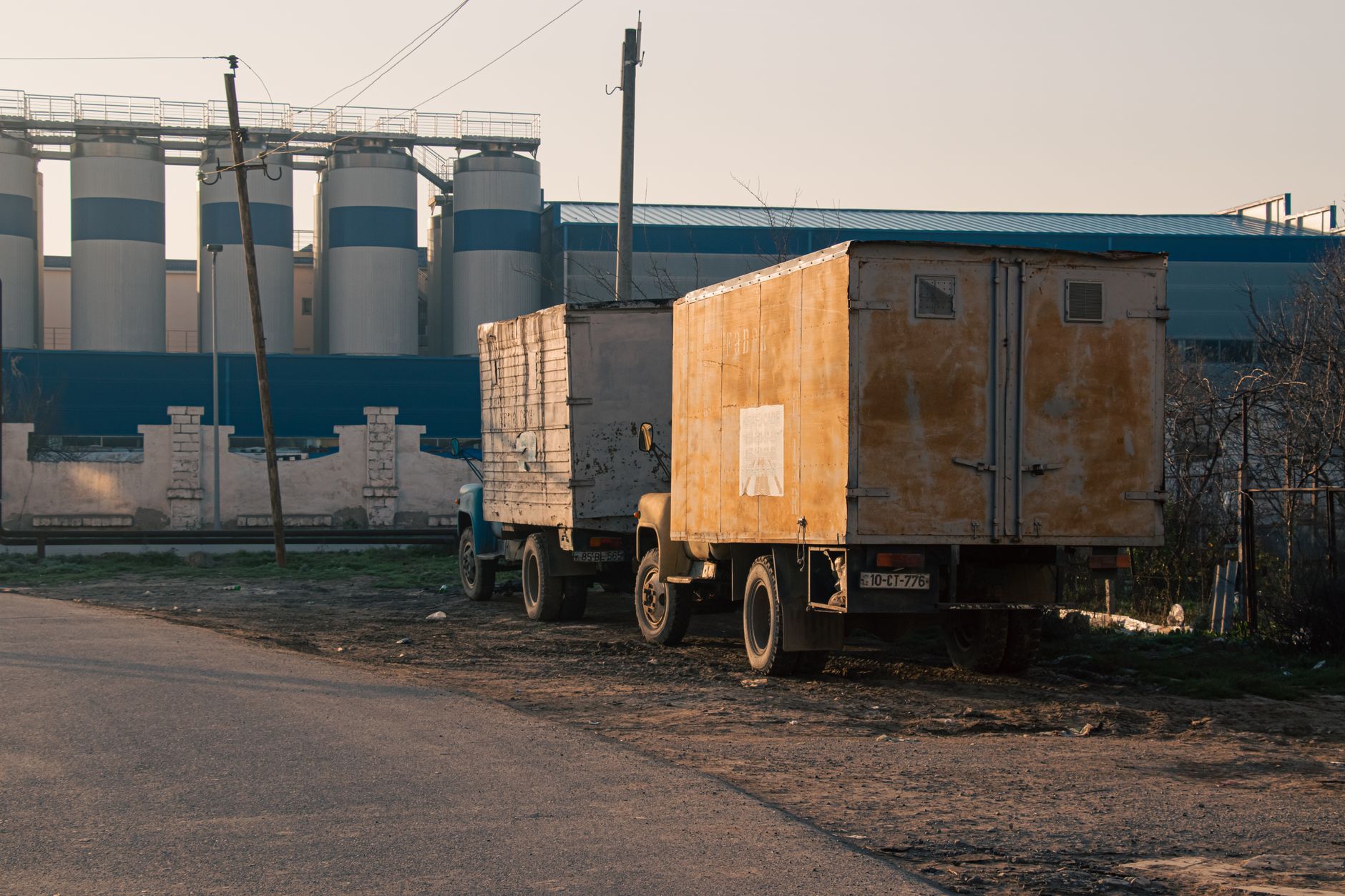 An aerial view of an industrial outdoor storage lot filled with truck trailers next to a highway.