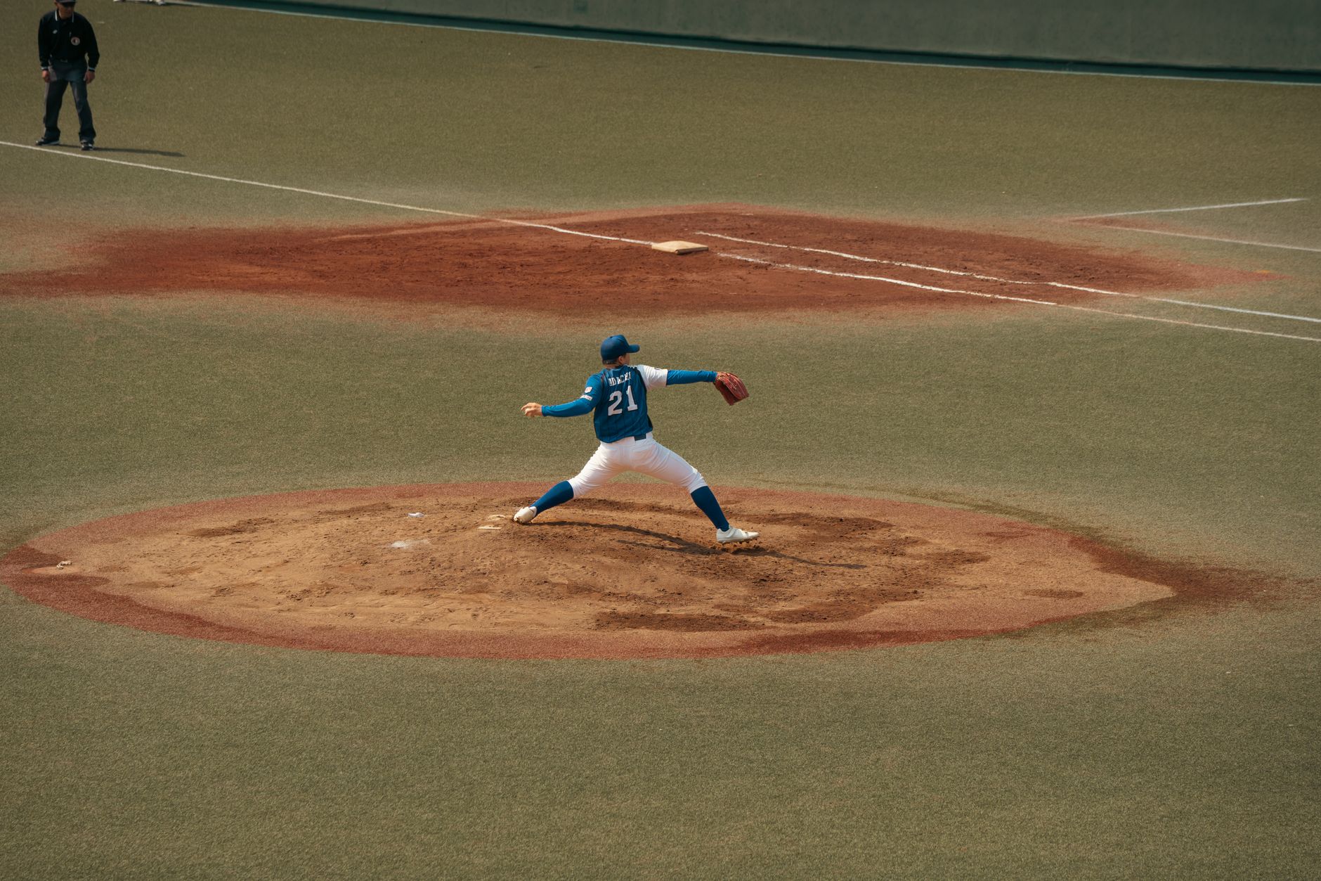 A highly detailed, photorealistic editorial illustration of a baseball pitcher's arm rendered as a glowing, complex financial asset with data points and stock ticker symbols integrated into the muscle fibers, against a dark, moody background.