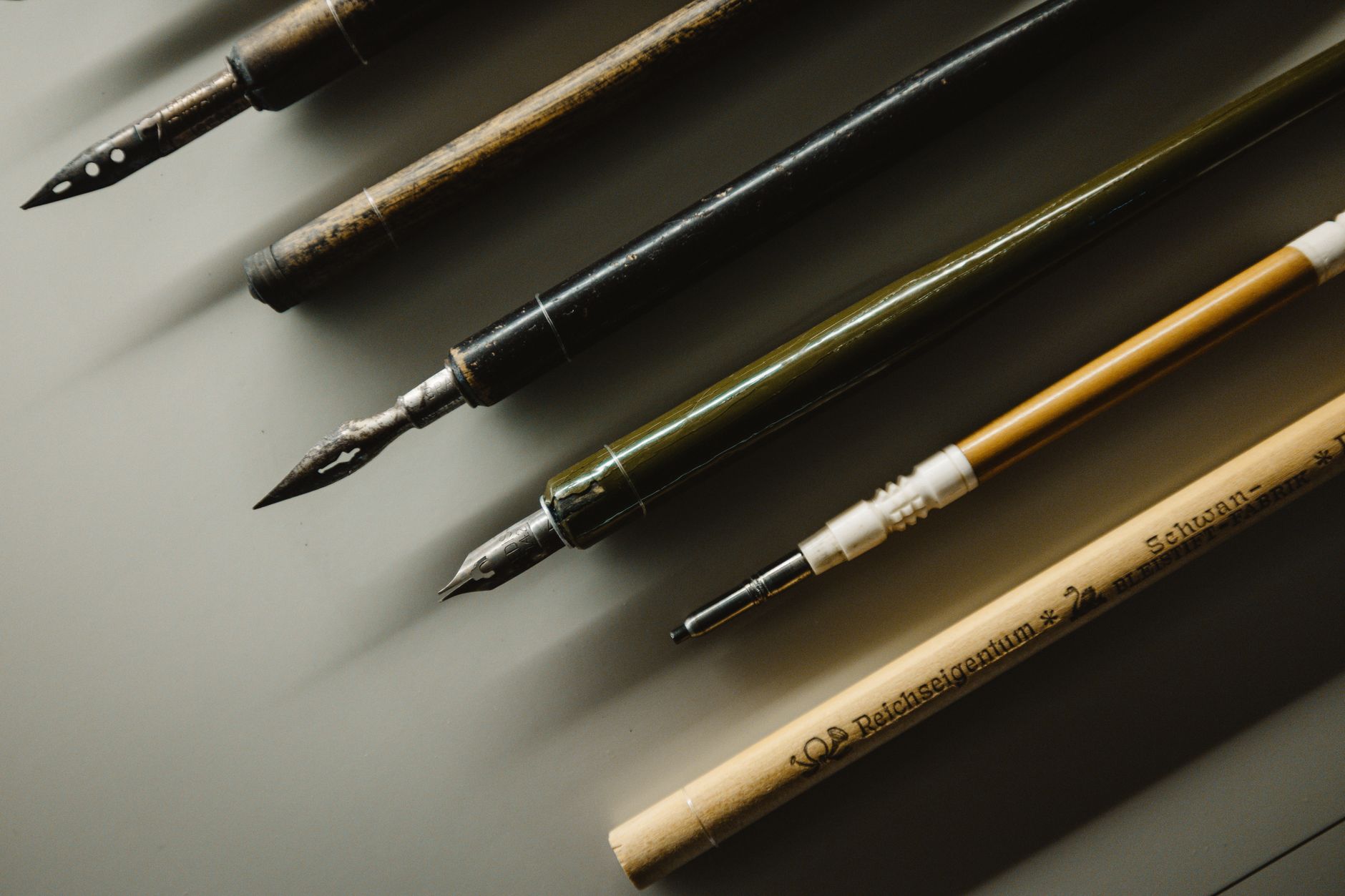 A luxury fountain pen resting on a glowing digital tablet displaying lines of code.