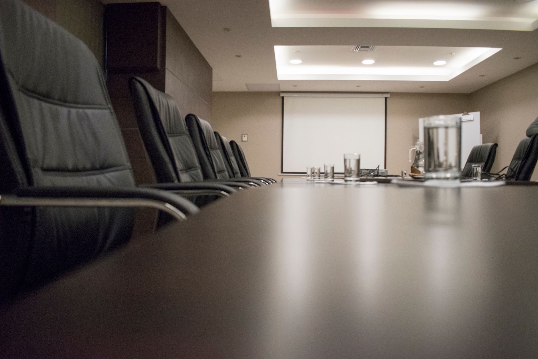 A stark, high-contrast illustration of a basketball court intersecting with a corporate boardroom table, glowing with financial data.