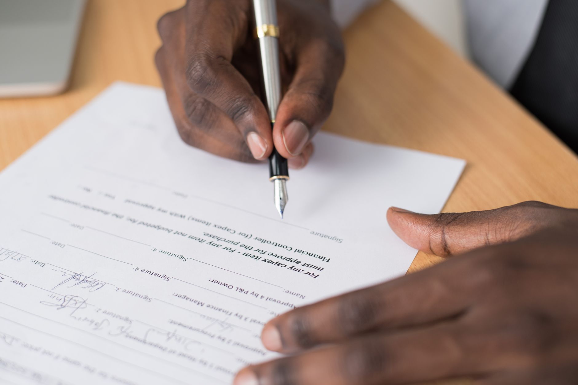 A stylized, photorealistic illustration of a golden shackle disguised as a corporate diploma or legal contract, placed on a modern glass office desk.