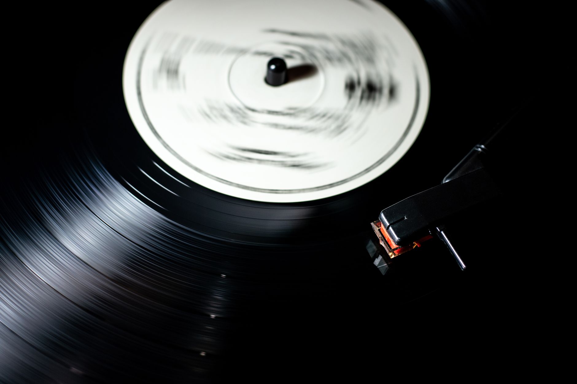 A vinyl record morphing into glowing digital data streams on a turntable