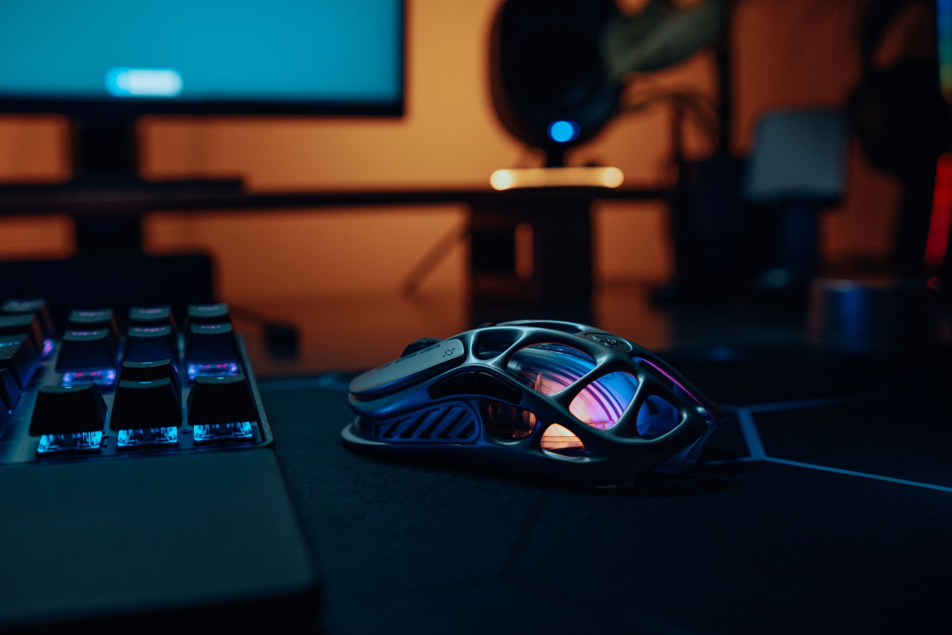 An older pair of hands resting on a high-end gaming peripheral, set against a dark, corporate aesthetic.
